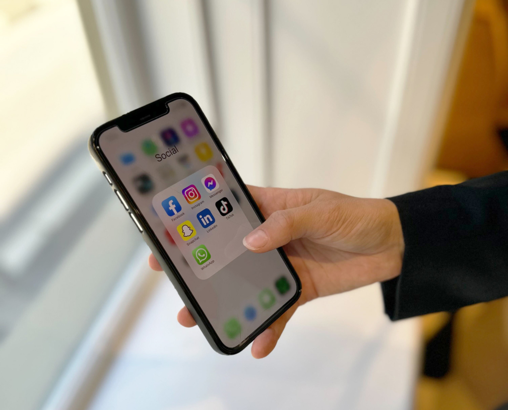 telefon med oversikt over ulike sosiale medier som apper