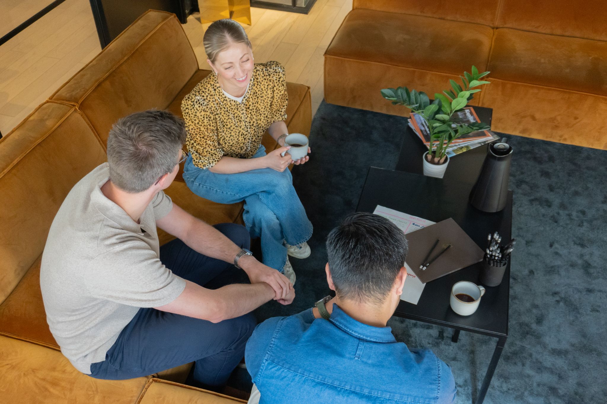 Tre personer som sitter i en sofa og diskuterer markedsføring